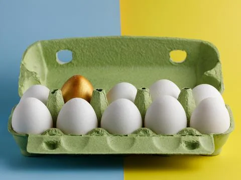 Open green box Easter chicken eggs on bicolor background One egg different co Stock Photos