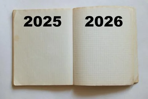 An open, gridded notebook with the words 2025 and 2026 written on the pages.. Stock Photos