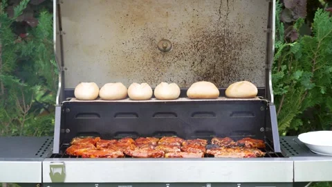 Open Grill with Pork Steaks and Bread Rolls in Garden Stock Footage 335698511