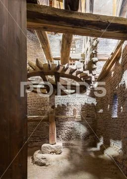 Open grunge door revealing aged water mill turning inside weathered mill Stock Photos