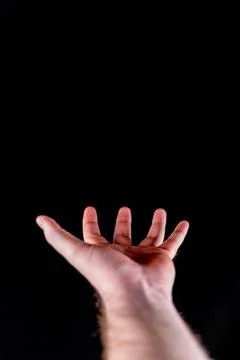Open Hand in a Dark Void with a Black Background Stock Photos