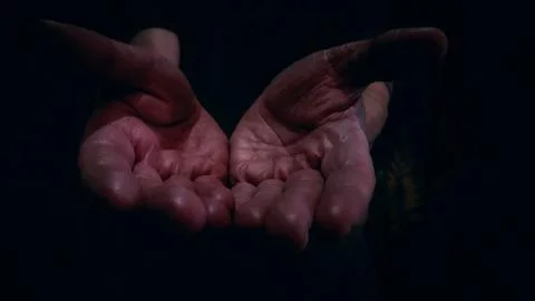 Open hands in dark dramatic lighting Stock Photos