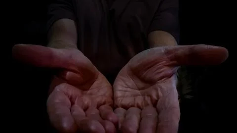 Open hands offering gesture in darkness Stock Photos