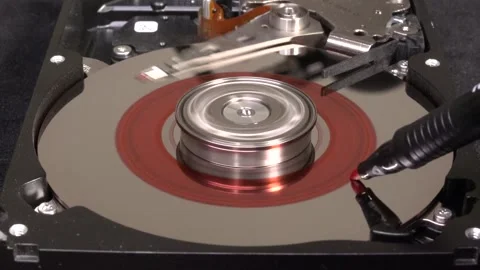 Open hard drive with red coloured platter, close-up view, starting rotation Stock Footage 321246098