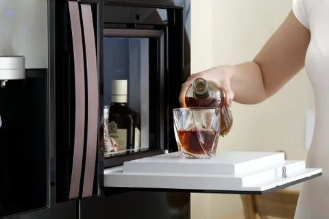 Open hatch of a mini bar in a modern refrigerator. home mini bar in the fridge Stock Photos