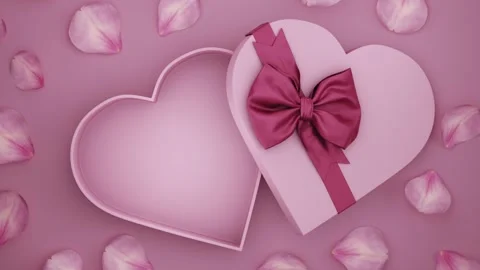 Open heart shaped present box wrapped with red bow tie and rose flower petals on Stock Footage 326059703