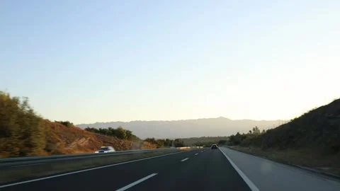 Open highway toward distant mountains during a peaceful summer evening road trip Stock Footage 341622262