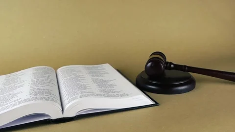 Open holy bible book next to a wooden justice gavel Stock Footage 343934861