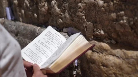 Open holy book-Torah in hands of praying woman near Wailing Wall in Jerusalem Stock Footage 183990900