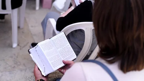Open holy book Torah in hands of praying woman near Western Wall Stock Footage 243170231