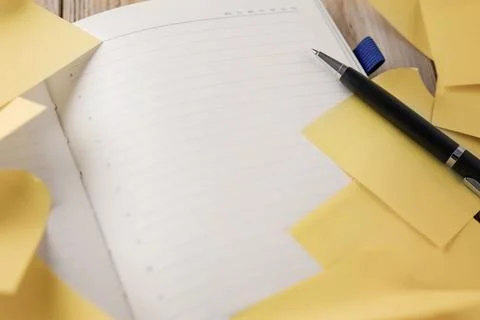 Open hourly planner with a pen and yellow sticky notes for a task list Stock Photos