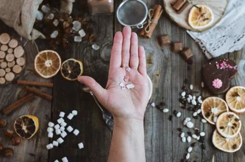 Open human palm on the background of the table with sweets Stock Photos