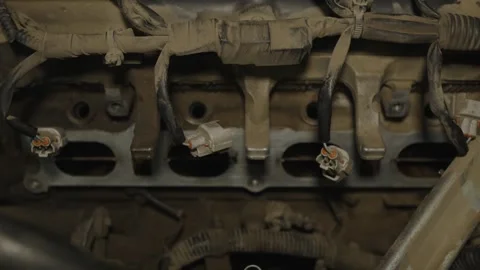 Open intake ports on a car engine cylinder head with disconnected wiring har Stock-Footage 340559560