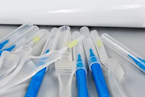 Open interdental brush on the same brushes covered with caps Stock Photos