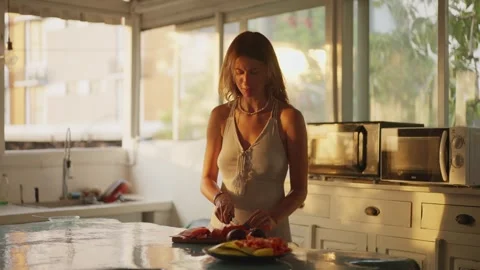 Open kitchen and woman's hands cutting papaya fruit, pawpaw fruit in half using Stock Footage 302371998