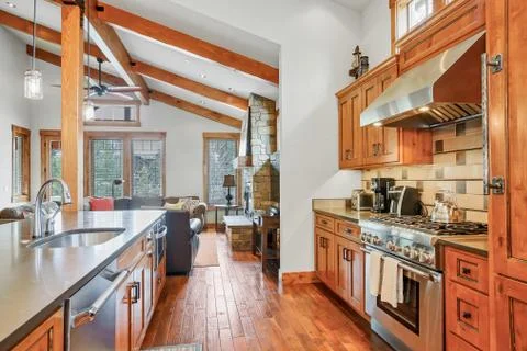 Open kitchen design features vaulted ceiling with wooden beams and  solid har Stock Photos
