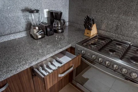Open kitchen drawer showing organized cutlery and utensils Stock Photos