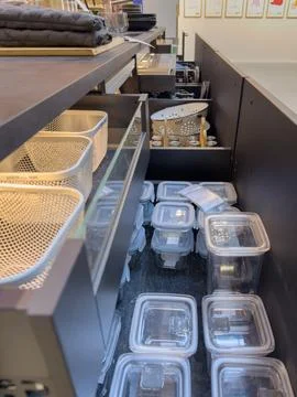 Open kitchen drawers with storage containers in IKEA store Stock Photos