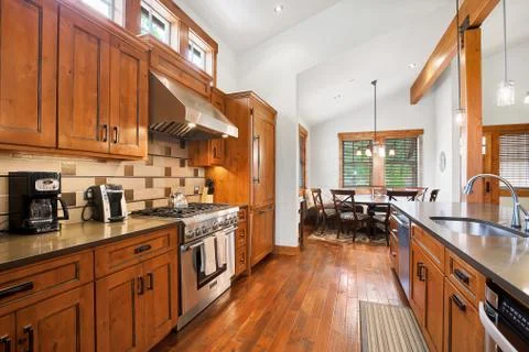 Open kitchen room with dining area, high vaulted ceiling and solid hardwood f Stock Photos