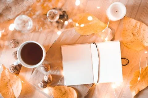Open lank notebook with cup of tea in autumn decor closeup. Top view. Stock Photos
