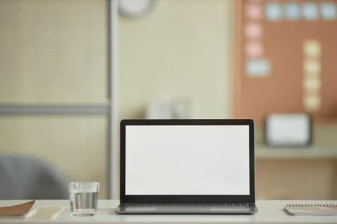 Open laptop with blank white screen mock up on desk in office Stock Photos