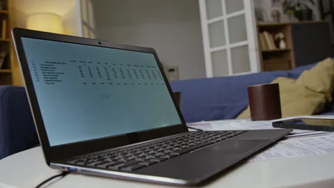 Open Laptop with Budgeting Data on Table with Documents Stock Footage 327681441