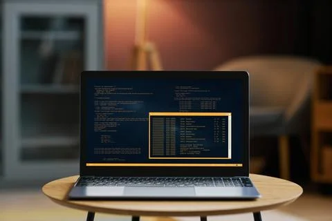 Open laptop with code on screen in dim home interior Stock Photos