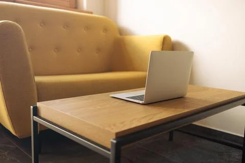 Open laptop on coffee table in modern living room interior without people Stock Photos