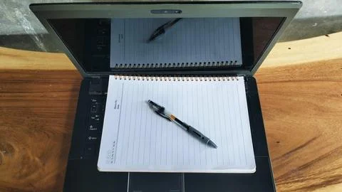 Open Laptop Computer with Spiral Notebook and Pen on Wooden Table Stockfoto's