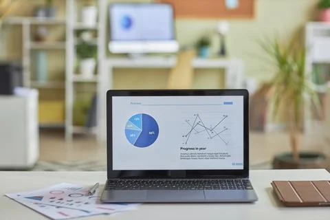 Open laptop computer with statistics data charts on screen on office workplace Foto stock