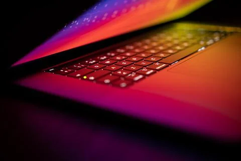 Open laptop with digital tablet and smartphone. Dark with colorfull technolog Stock Photos