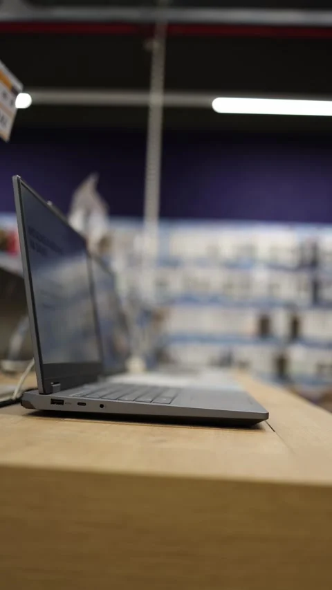 Open laptop displayed on retail table inside a modern electronics store Stock Footage 345357741