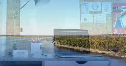 Open laptop displaying code in office workspace, with chemistry posters and Stock Photos