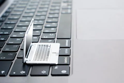 Open Laptop with a Tiny Notebook Replica on Top Foto stock