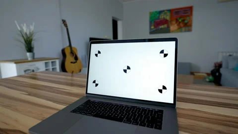 Open laptop with white screen stands on wooden table Stock Footage 228921476