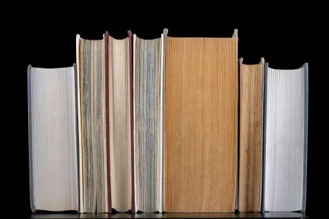 An open large book against the backdrop of a row of paper publications. Heap  Stock Photos
