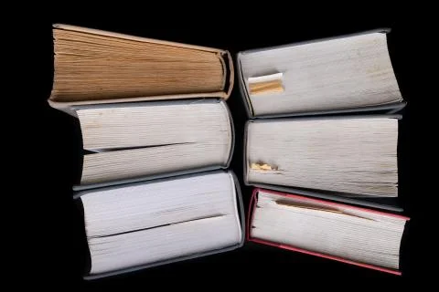 An open large book against the backdrop of a row of paper publications. Heap  Stock Photos