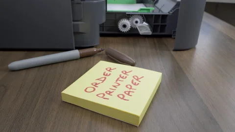An open laser printer with a note to order printer paper. Video stock 140983988