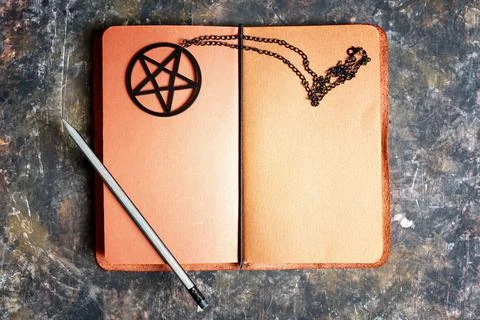 Open leather notebook diary and pentagram necklace Stock-Fotos