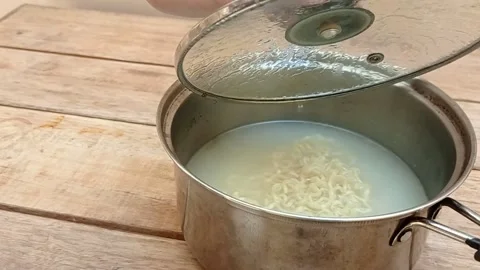 Open the lid of the pot containing boiled noodles Stock Footage 145377726