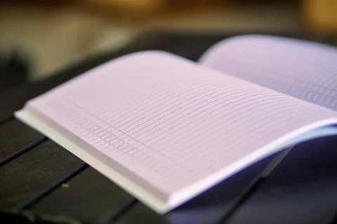 An open lined notebook on a table with soft lighting, representing the concepts Stock Photos