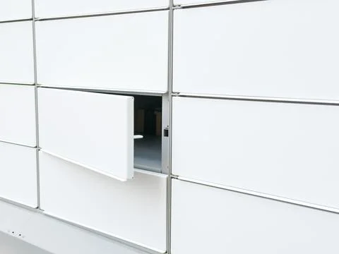 Open locker in a modern white parcel locker system for delivery and storage Stock Photos