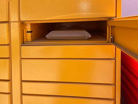Open locker with a package inside at a collection point. Stock Photos