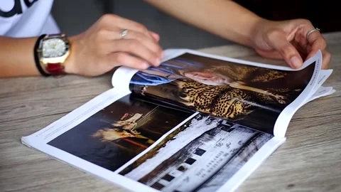 Open the magazine sheet on the table Stock Footage 240987911
