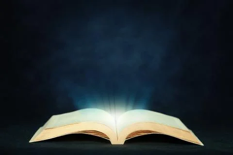 Open magic book with light Stock Photos