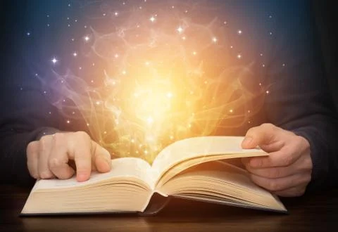 Open magic book with shining light sparkles Stock Photos
