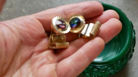 Open malachite casket and taking golden cufflinks Stockbeeldmateriaal 96024096