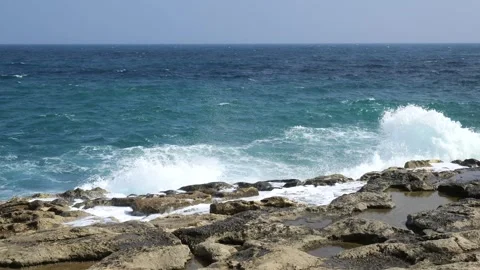 Open mediterranean waves roll toward a rocky malta shore tide pools scattered Stock Footage 341800813