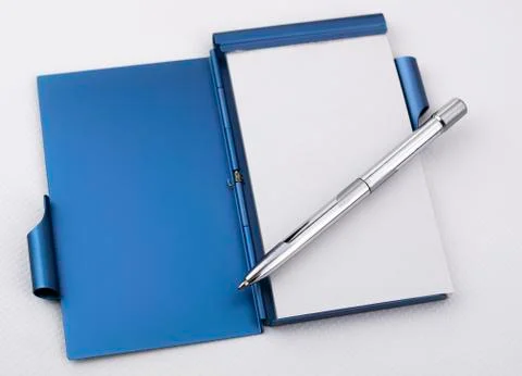Open metallic notepad with white sheets and chrome pen Stock Photos