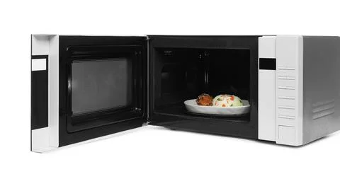Open microwave oven with cooked rice and chicken isolated on white Stock Photos